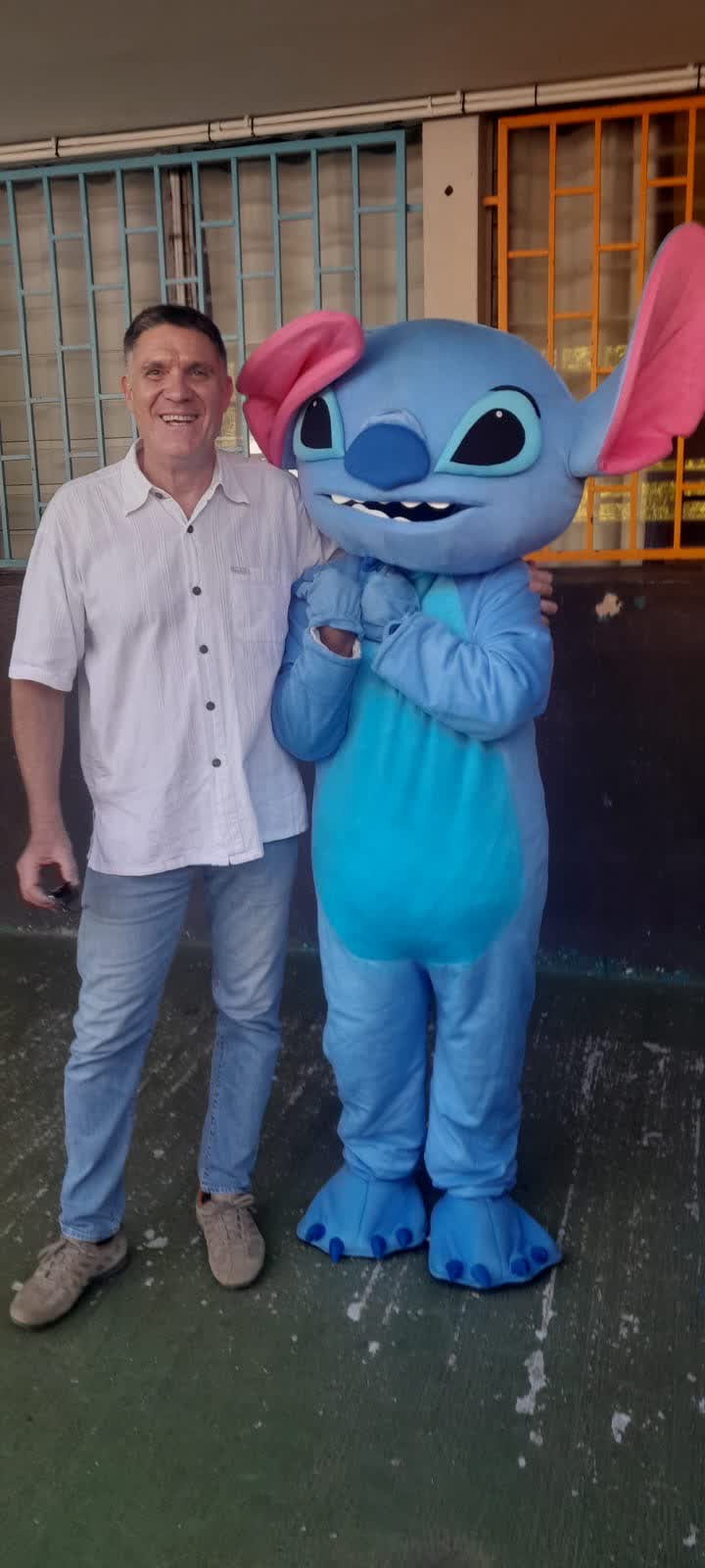 Invité posant avec la mascotte géante lors d'une animation à La Réunion